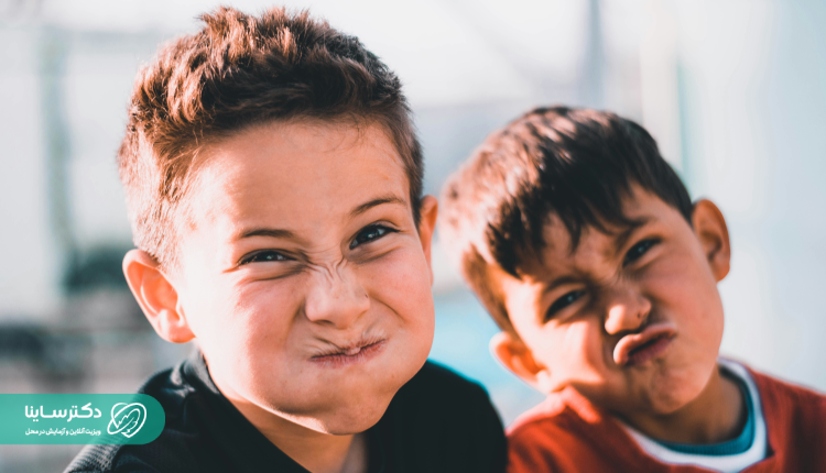 Two boys making funny faces, reflecting high energy and impulsivity often associated with ADHD kids causes.