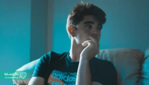 Alt text: A teenage boy sitting on a couch, gazing off to the side with concern – Paranoid personality disorder