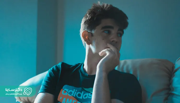 Alt text: A teenage boy sitting on a couch, gazing off to the side with concern – Paranoid personality disorder